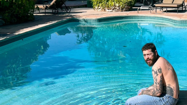 Album cover for AUSTIN. Features Post Malone sitting shirtless on the side of a pool wearing jeans. He is staring towards the camera but squinting due to the sunlight in his face.